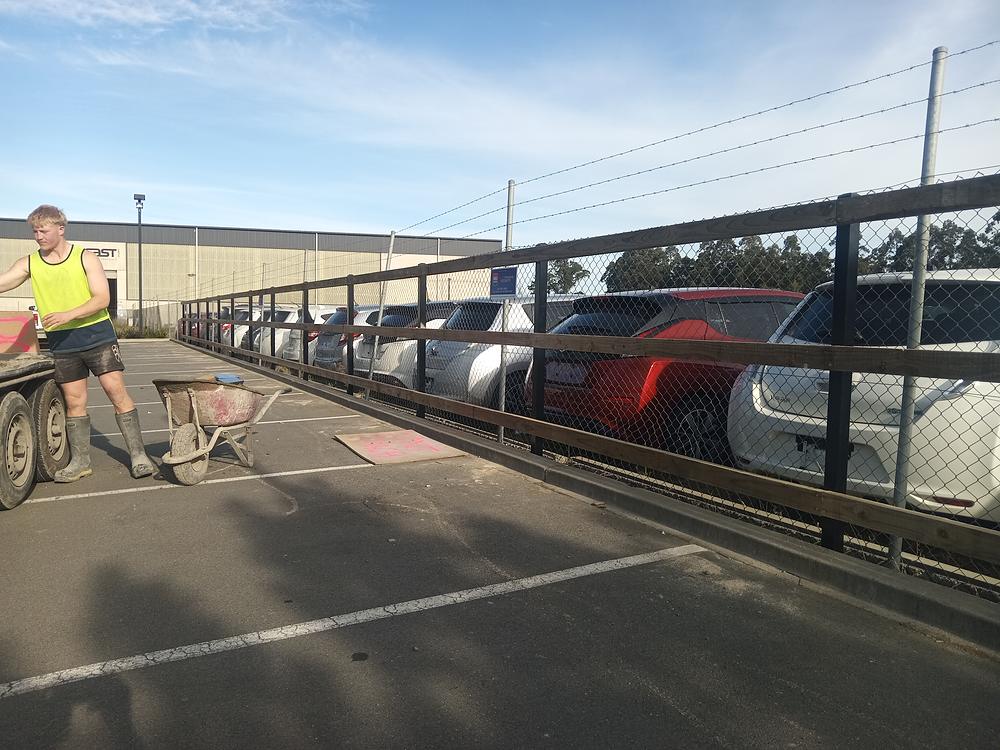 A Vogel fencer building a steel fence line along a carpark boundary