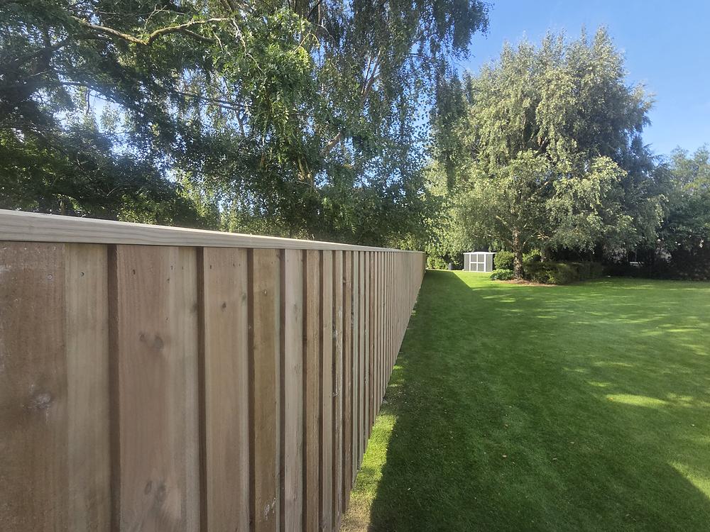 Timber paling fence running down the side of a large lawn